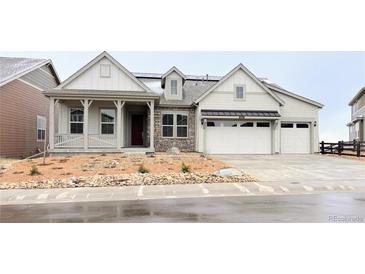 Charming home featuring a stone facade, covered porch, three-car garage and low maintenance landscaping at 3929 Treadway Pt, Castle Rock, CO 80108