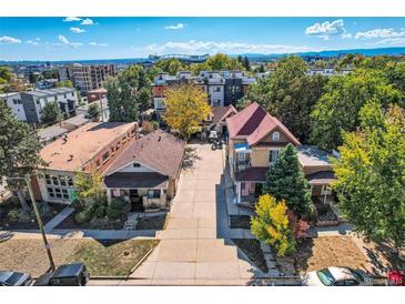 Charming residential neighborhood featuring well-maintained homes, mature trees, and a glimpse of the city skyline in the background at 2736 W 24Th Ave, Denver, CO 80211