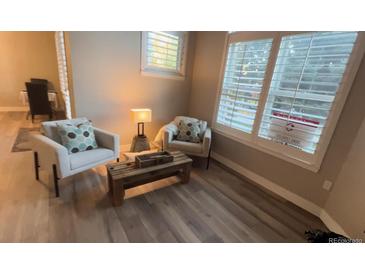 Inviting sitting area features wood floors, comfortable seating and a window with plantation shutters at 3701 Arapahoe Ave # 106, Boulder, CO 80303