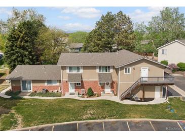 Inviting townhome complex featuring a charming exterior, mature trees and landscaping, and ample parking at 2271 Coronado N Pkwy # D, Denver, CO 80229
