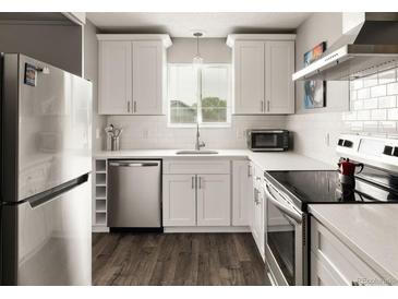 Bright kitchen features stainless steel appliances, white cabinets, subway tile backsplash and sleek countertop at 2271 Coronado N Pkwy # D, Denver, CO 80229