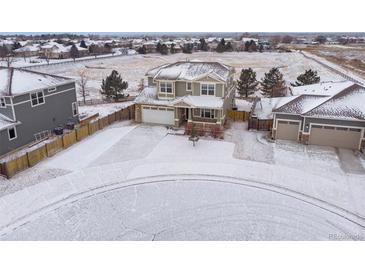 Beautiful two-story home with attached garage in a snowy neighborhood at 1523 Honeysuckle Ct, Brighton, CO 80601