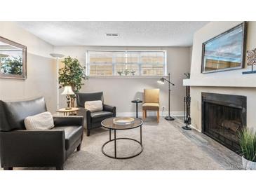 Living room featuring a brick fireplace, large window, neutral paint and carpet at 9110 E Girard Ave # 1, Denver, CO 80231