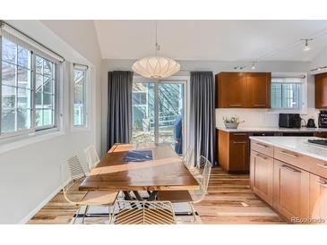 Bright dining room with wood table, modern lighting, and sliding door to the back yard at 4861 Curie Ct, Boulder, CO 80301