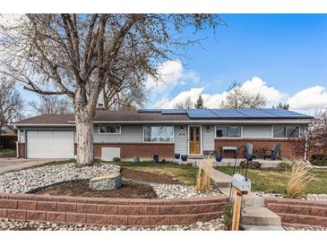 Charming ranch-style home with brick accents, solar panels, a well-kept yard, and mature landscaping at 6719 W 70Th Ave, Arvada, CO 80003