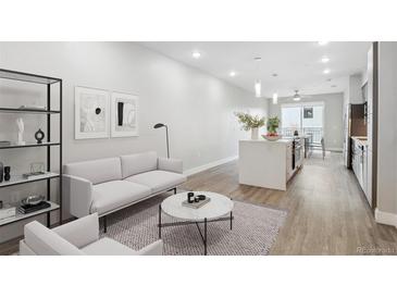 Bright living room with modern furnishings, wood floors, and an open layout leading to the kitchen at 3500 S Corona St # 409, Englewood, CO 80113