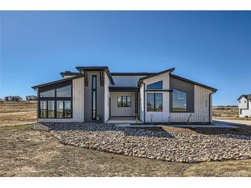 Striking modern home with a unique architectural design and professional rock landscaping at 8648 Carneros Ct, Parker, CO 80138