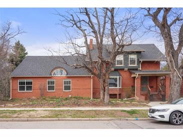 Charming two-story brick home featuring mature trees and a well-maintained front yard on a sunny day at 841 Niagara St, Denver, CO 80220