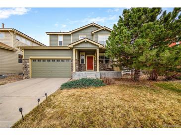 Charming two-story home with a well-manicured lawn, stone accents, and an attached two car garage at 23662 E Alabama Dr, Aurora, CO 80018