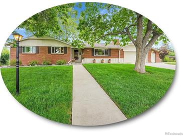Charming brick home with a well-manicured lawn and mature trees, creating a welcoming curb appeal at 595 W Lake Ave, Littleton, CO 80120