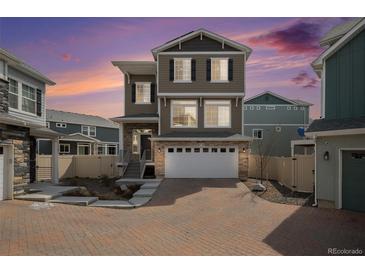 Attractive exterior of a multi-story home showcasing a two-car garage, stone accents, and well-maintained landscaping at 4108 N Quatar Ct, Aurora, CO 80019
