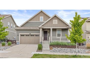 Charming home featuring a landscaped front yard, covered porch, and attached two-car garage at 757 Cabot Dr, Erie, CO 80516