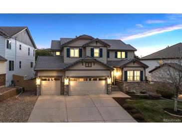 Charming two-story home featuring a three-car garage, stone accents, and a welcoming front entrance at 10969 Valleybrook Cir, Highlands Ranch, CO 80130