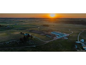 Expansive aerial view of horse property with riding arena at sunset at 27115 County Road 13, Elizabeth, CO 80107
