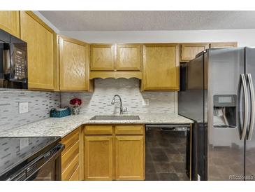Bright kitchen features granite countertops and black appliances at 13626 E Bates Ave # 207, Aurora, CO 80014