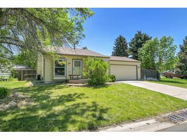 Charming ranch-style home featuring a well-maintained lawn, mature trees, and an attached two-car garage at 8848 Prickly Pear Cir, Parker, CO 80134