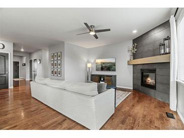 Comfortable living room with hardwood floors, a fireplace, and a ceiling fan at 3107 S Nepal Way, Aurora, CO 80013