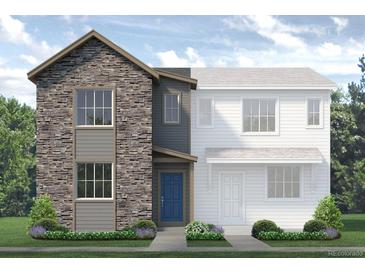 Charming two-story home featuring stone accents, blue door, green lawn, and tasteful landscaping at 1440 Coral Pl, Longmont, CO 80501