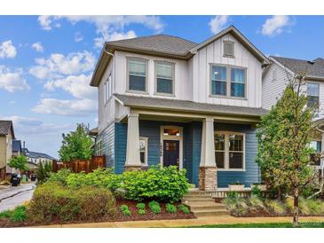 Charming two-story home with a beautifully landscaped front yard and inviting porch at 10360 E 57Th Pl, Denver, CO 80238