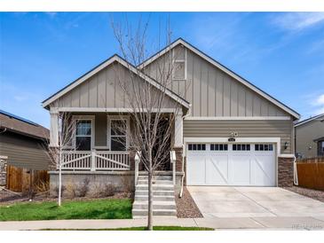 Charming home featuring a well-manicured lawn, white garage door, and inviting front porch at 1056 S Elk Way, Aurora, CO 80018