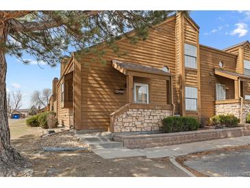 Charming multi-level home featuring wood siding, stone accents, and a landscaped front yard at 2569 Devonshire Ct # 72, Denver, CO 80229