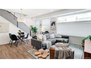Bright living space with modern furniture, light wood floors, and staircase with iron railings at 1238 Quitman St # 2, Denver, CO 80204