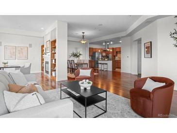 Open living room showcasing hardwood floors, modern furniture, and a built-in bookcase at 2200 S University Blvd # 513, Denver, CO 80210