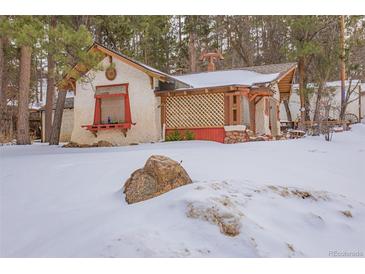 Quaint cottage nestled in snowy landscape, charming details and unique character at 127 Shady Ln, Palmer Lake, CO 80133