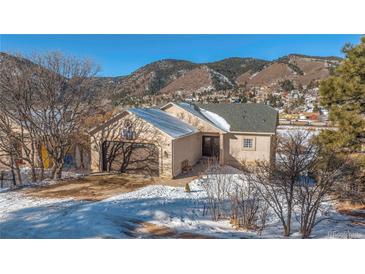 House exterior showcasing a ranch style home with a mountain backdrop at 110 Oakdale Dr, Palmer Lake, CO 80132