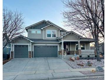 Charming two-story home featuring a wide driveway and a welcoming covered front porch at 458 Mazzini St, Erie, CO 80516