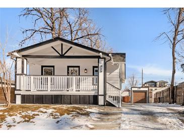 Charming home featuring a welcoming porch with a white railing and classic black and white exterior paint scheme at 1960 S Franklin St, Denver, CO 80210