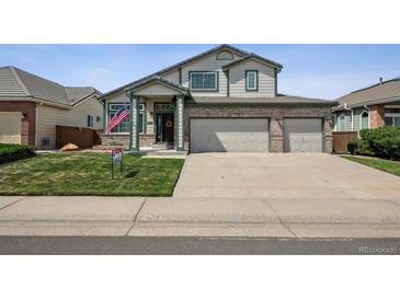 Charming two-story home with a three car garage, landscaped yard, and an American flag at 3418 Oak Leaf Pl, Highlands Ranch, CO 80129