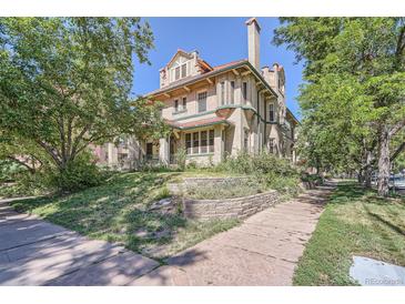 An inviting exterior view shows a well-maintained historic home with a charming brick facade and mature trees at 1000 N Logan St, Denver, CO 80203