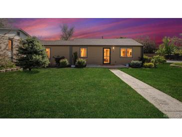 Charming single-story home featuring a well-maintained lawn and inviting walkway to front door at twilight at 998 S Leyden St, Denver, CO 80224