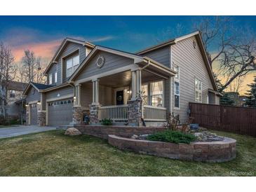 Charming two-story home with a covered front porch and well-maintained front yard and a two car garage at 1831 Ashford Cir, Longmont, CO 80504