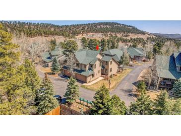 Scenic mountain neighborhood featuring townhomes with mature trees and convenient garages at 1294 Red Lodge Dr, Evergreen, CO 80439