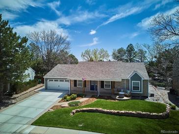 Aerial view of a charming home with a manicured lawn, a lovely front porch, and an attached two-car garage at 5172 S Cody Ct, Littleton, CO 80123