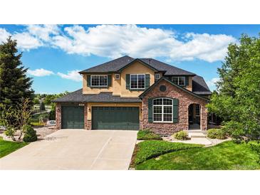 Beautiful two-story home featuring manicured lawn, three-car garage, stone accents, and lush landscaping at 1647 Harris Ct, Erie, CO 80516