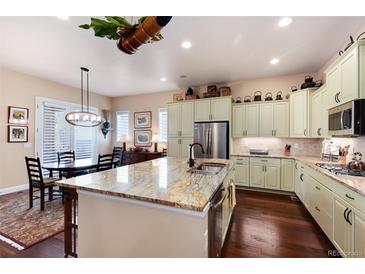 Bright kitchen boasts a large island with granite countertops and stainless steel appliances at 16 Willowcroft Dr, Littleton, CO 80123