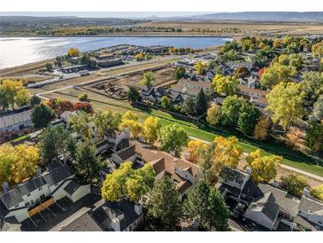 A beautiful aerial view of townhomes showcases vibrant fall foliage near a serene lake and community at 5374 W Canyon Trl # B, Littleton, CO 80128