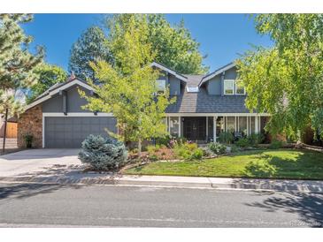 Charming two-story home with a beautifully landscaped front yard and a gray two car garage at 7844 S Eudora Cir, Centennial, CO 80122