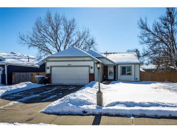 White house with attached garage, snowy yard, and brick pillars at 1621 Flemming Dr, Longmont, CO 80501