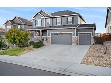 Two-story house with gray siding, stone accents, and a three-car garage at 7478 Oasis Dr, Castle Rock, CO 80108