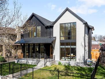Striking two-story home with black and white exterior, large windows, and manicured lawn at 754 S York St, Denver, CO 80209