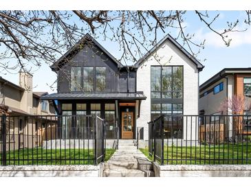 Beautiful two-story home with modern design, black trim, a manicured lawn, and a black metal fence at 754 S York St, Denver, CO 80209