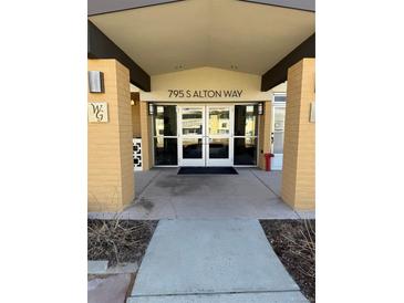 The building entrance is covered and clearly marked with the address above the glass doors at 795 S Alton Way # 11C, Denver, CO 80247