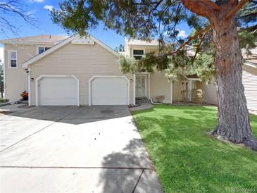 Charming home featuring a two-car garage, well-manicured lawn, and mature trees at 389 S Kalispell Way # C, Aurora, CO 80017