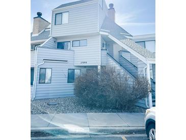 Charming two-story condo featuring a light blue exterior and well-maintained landscaping at 17090 E Ford Dr # 209, Aurora, CO 80017