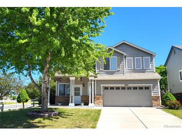 Charming two-story home featuring a well-manicured lawn, mature tree, and a two-car garage at 3554 S Jebel Cir, Aurora, CO 80013