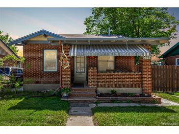 Charming brick home with a covered front porch and well-maintained lawn at 2564 S Acoma St, Denver, CO 80223